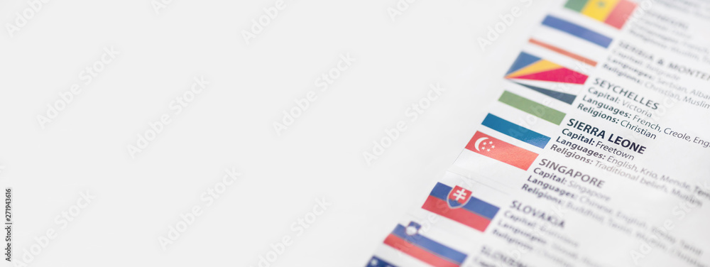 Fototapeta premium List of countries with national flag, languages and religions of these countries. Paper background with focus on Republic of Sierra Leone, informally Salone, with capital city Freetown. 