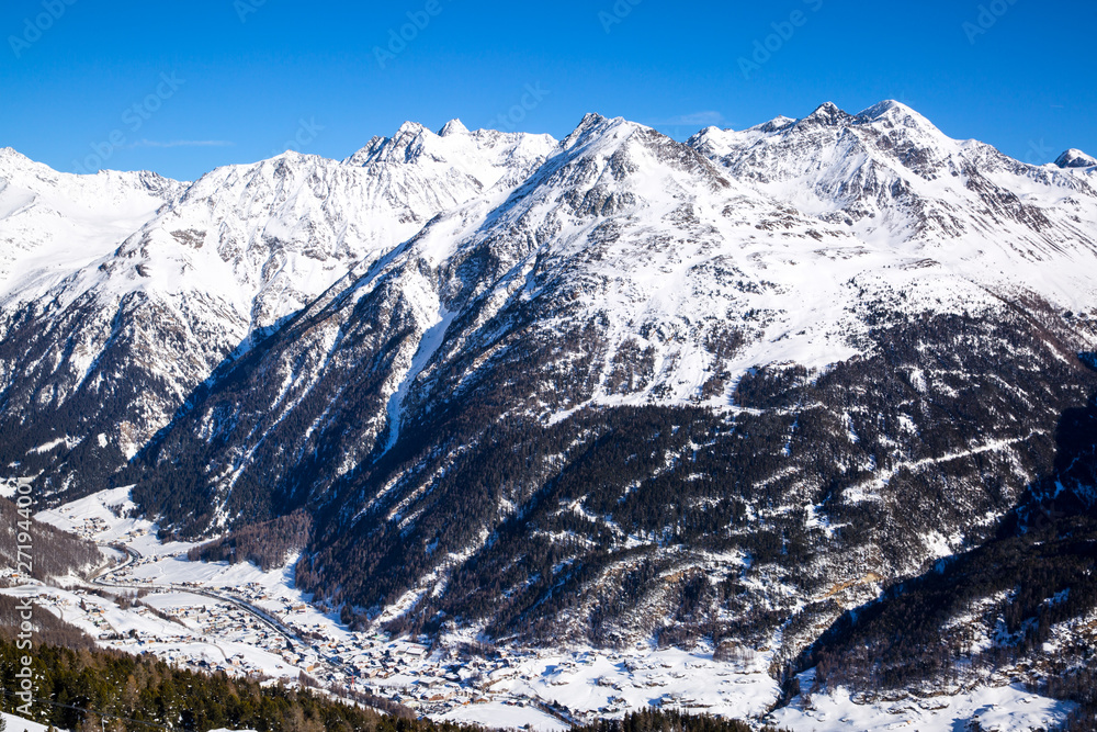 Rocky Alps, covered with snow. Ski village in the valley. Beautiful winter panoramic view in Tirol, Austria. Rocky Alps, covered with snow. Ski village in the valley. Beautiful winter panoramic view in Tirol, Austria.