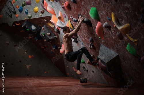 Athletic man practicing in a bouldering gym
