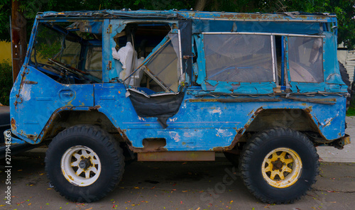 dilapidated rusty blue truck on the middle of the street