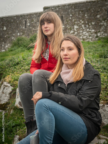 Two young woman relax in the green landscape of Ireland - travel photography © 4kclips