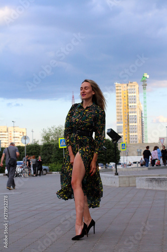 girl in green dress with long legs on city street