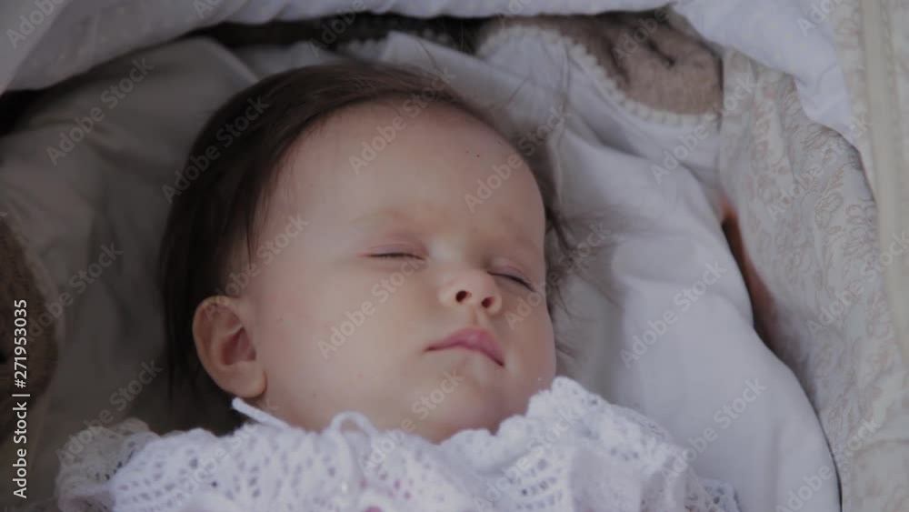 Beautiful little girl sleeping in a baby carriage on the street. Beautiful little girl sleeping in a baby carriage on the street.