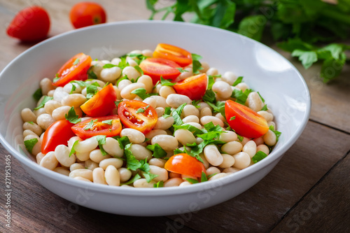 White bean salad with cherry tomatoes and parsley in bowl