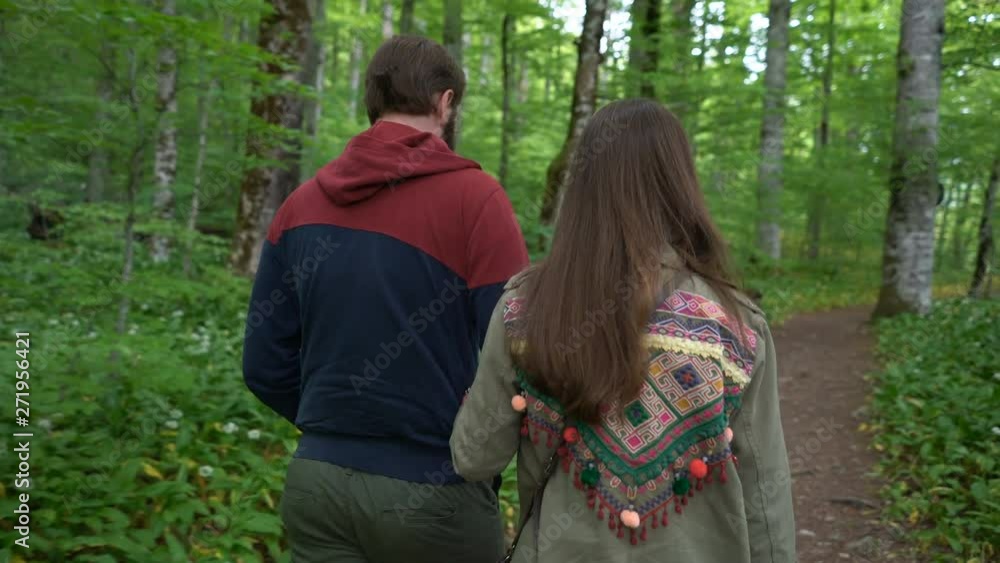couple walking along a forest path couple walking along a forest path