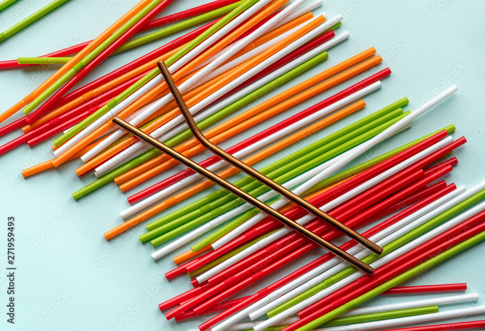 Flat lay reusable stainless steel straws and disposable plastic straws on a blue background. Sustainable lifestyle and zero waste concept, plastic free Flat lay reusable stainless steel straws and disposable plastic straws on a blue background. Sustainable lifestyle and zero waste concept, plastic free