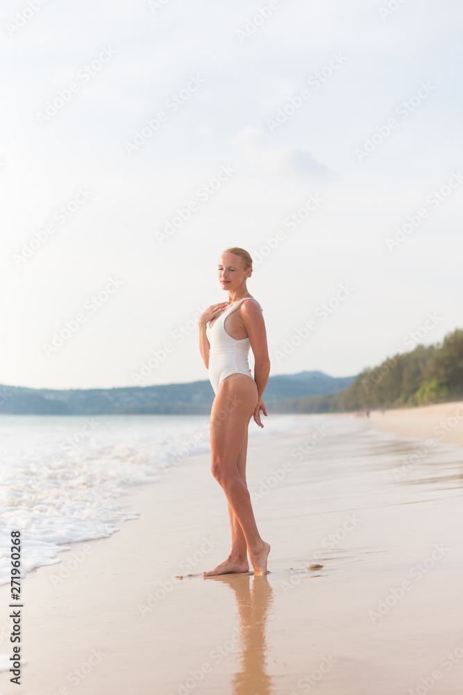 Model on the beach in white dress 