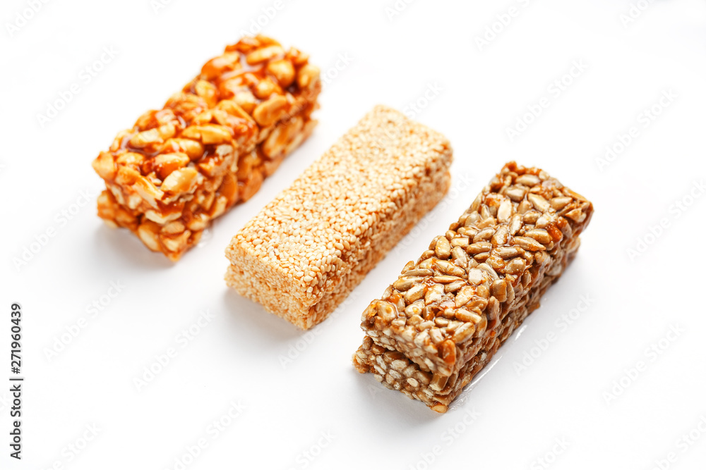 Grain granola bar with peanuts, sesame and seeds in a row on a white background. Top view Three assorted bars, isolate Grain granola bar with peanuts, sesame and seeds in a row on a white background. Top view Three assorted bars, isolate