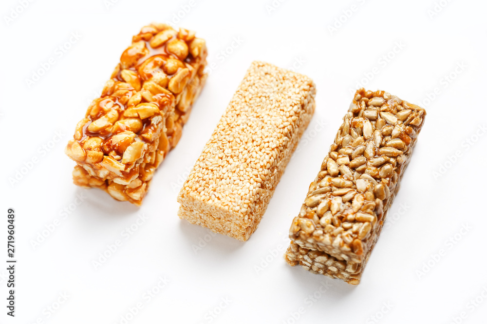 Grain granola bar with peanuts, sesame and seeds in a row on a white background. Top view Three assorted bars, isolate Grain granola bar with peanuts, sesame and seeds in a row on a white background. Top view Three assorted bars, isolate