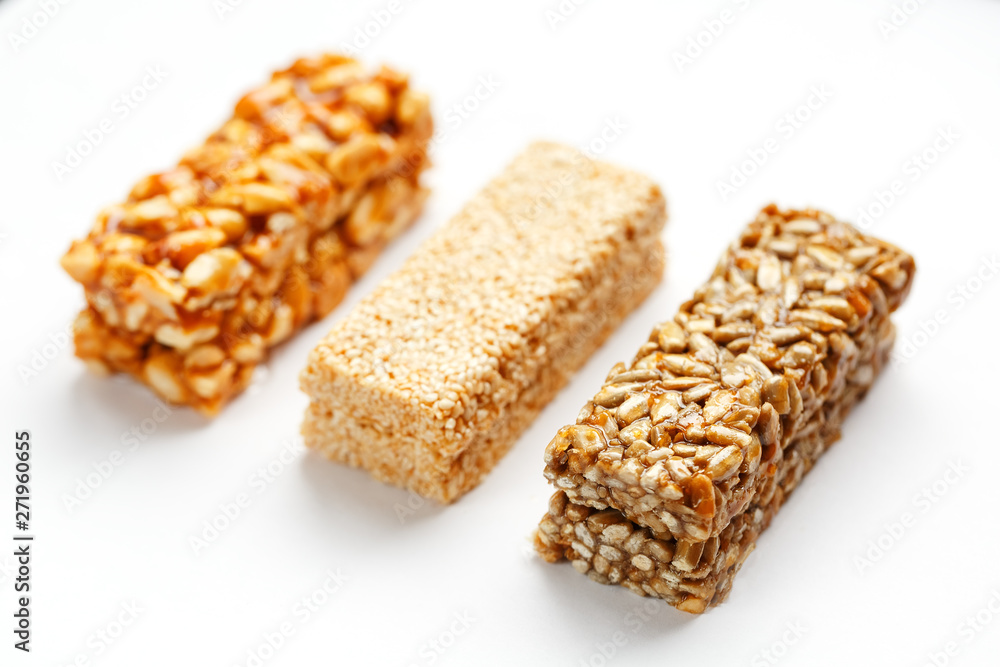 Grain granola bar with peanuts, sesame and seeds in a row on a white background. Top view Three assorted bars, isolate Grain granola bar with peanuts, sesame and seeds in a row on a white background. Top view Three assorted bars, isolate