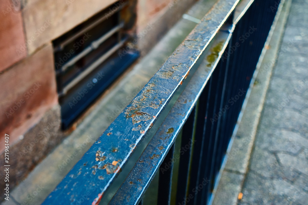 Railing of a house on the sidewalk with rust