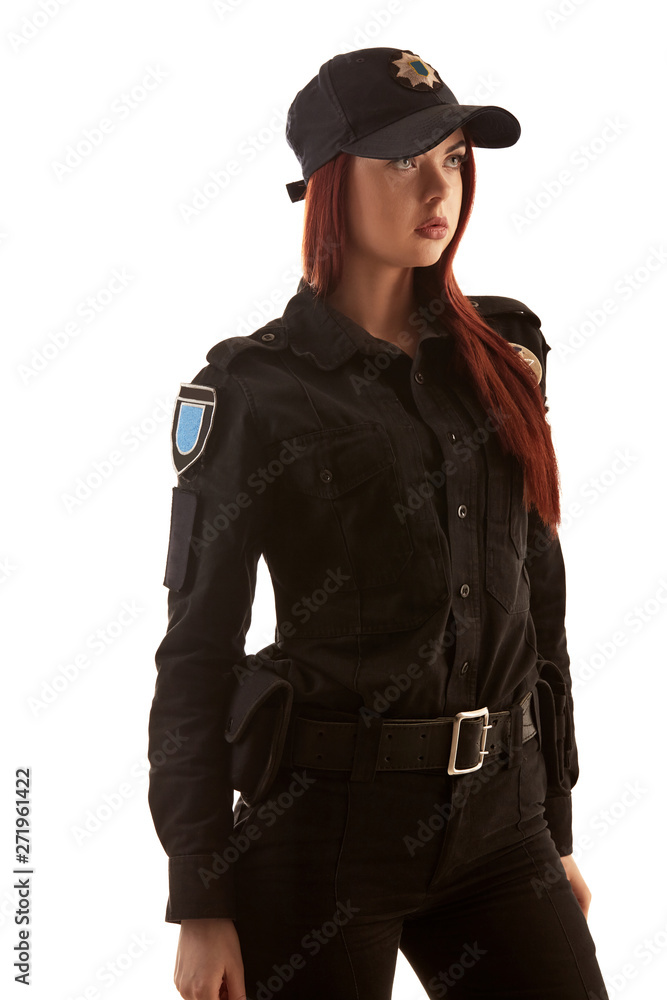 Redheaded female police officer is posing for the camera isolated on white background.