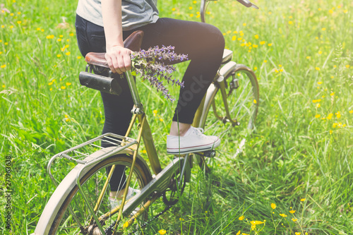 Close up of woman on vintage bike in nature. Summer or spring season concept.