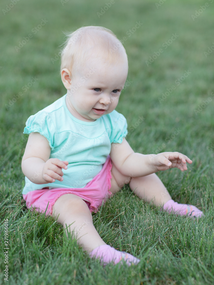 Happiness Baby girl sitting on the grass in field Happiness Baby girl sitting on the grass in field