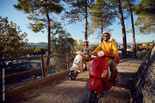 Fotografía Happy couple riding on a scooter in old European town on vacation