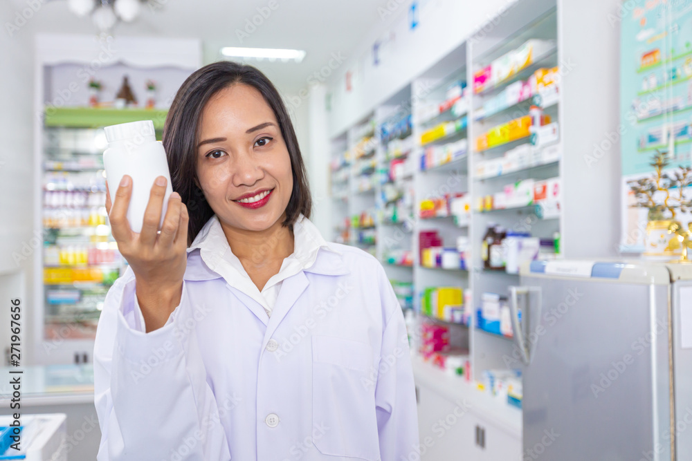 Pharmacist holding medicine bottle in pharmacy. Health care and medical concept.