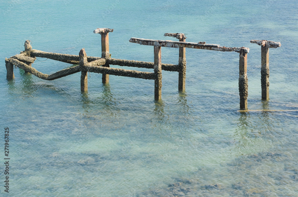 Coastal landscape with old broken pier,Old harbor ruins in the blue sea.