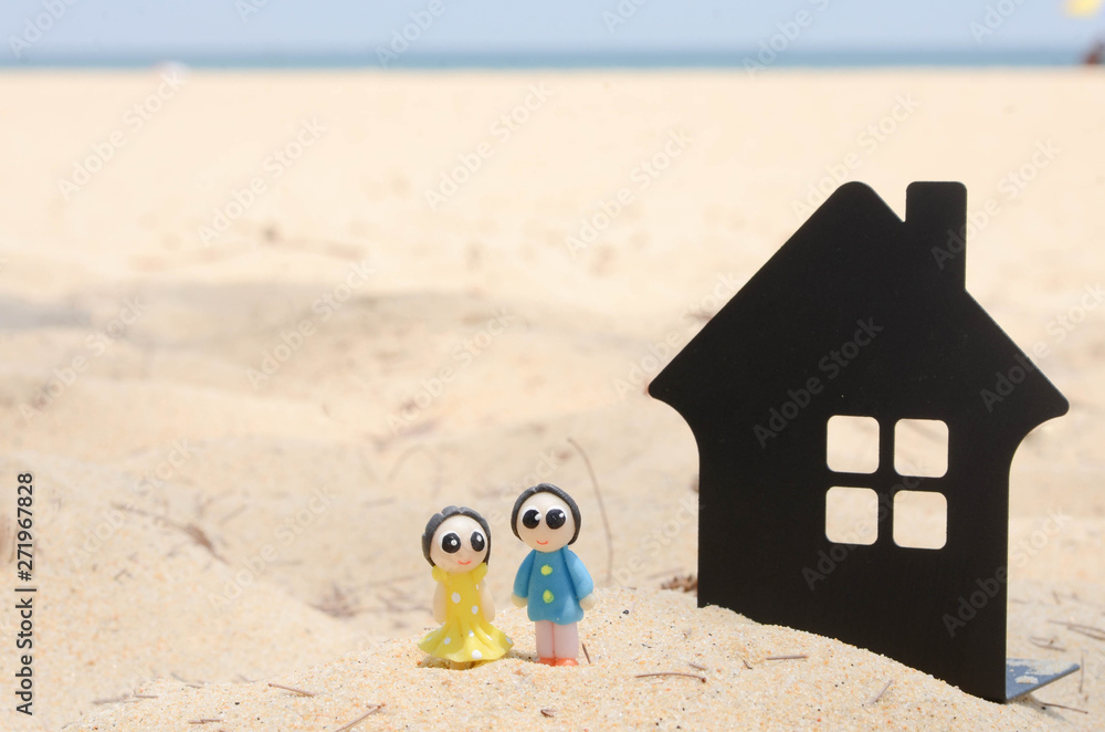 Naklejka premium miniature couple and miniature house on the beautiful tropical beach.