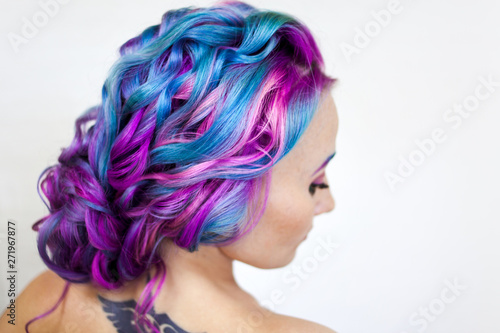 Elegant hairstyle of curls on long colored hair, styling. Bright color coloring, concept.