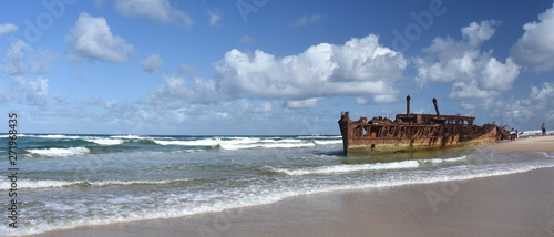 The rusty wreck of the vessel Maheno on the shores of Fraser Island (Queensland, Australia). The antique rusty and damaged boat and corrosion in the ocean sea.