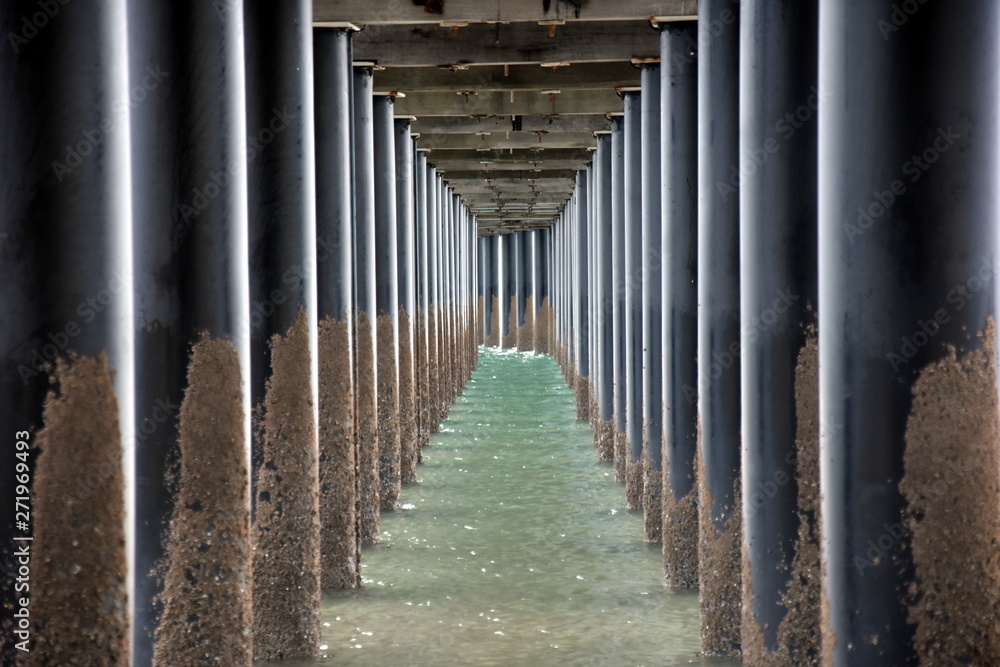 Under Urangan pier perspective view. Under a pier in Hervey Bay (Queensland, Australia), showing the structure of the pilings and support structure.