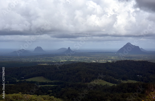 Panoramic view of Glass House Mountains National Park on Sunshine Coast (Queensland, Australia). The Glasshouse Mountains are silhouetted in the afternoon sunlight.