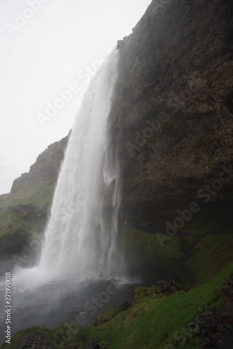 beautiful iceland waterfall with rocks and skies