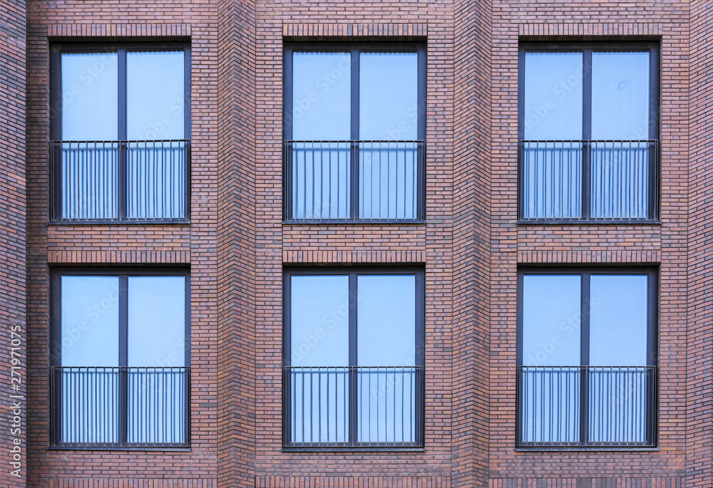 Fototapeta premium Residential building in loft style. Large Windows in a red brick wall.