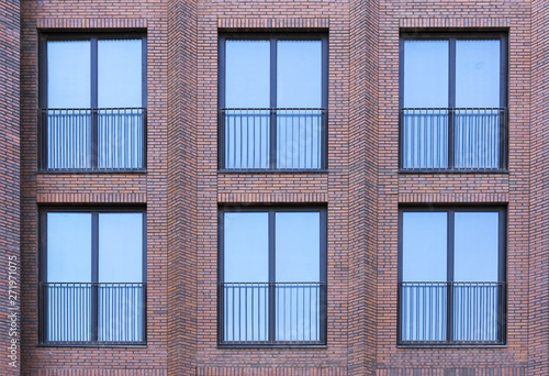 Residential building in loft style. Large Windows in a red brick wall.