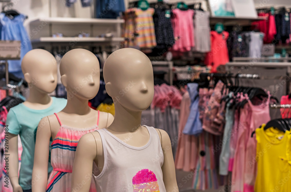 Children's mannequins with summer clothes in the store.