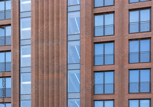 Residential building in loft style. Large Windows in a red brick wall.