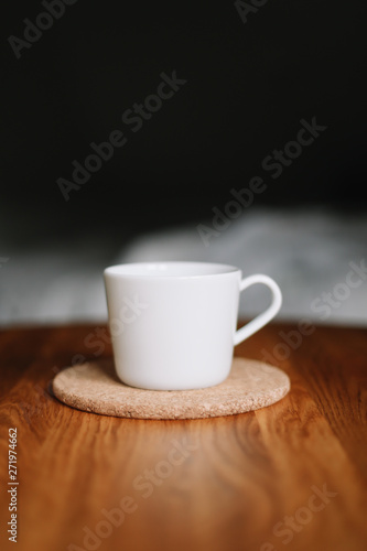 A white cup on wooden table. Morning coffee 