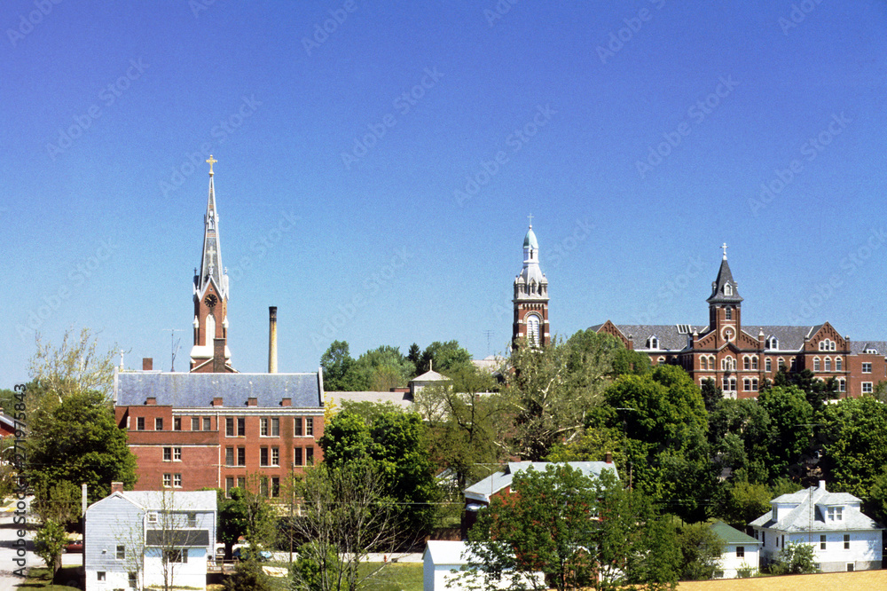 Town with three church spires under a bright blue sky