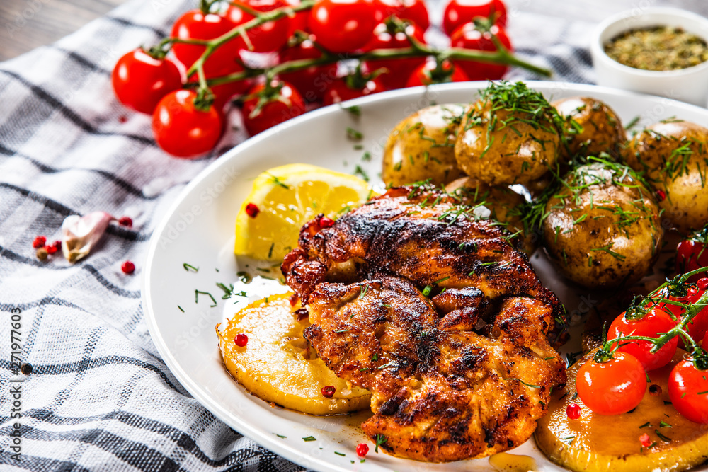 Grilled chicken fillet and vegetables on white plate Grilled chicken fillet and vegetables on white plate