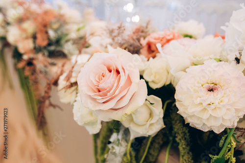 Gorgeous luxury wedding table arrangement  floral centerpiece close up. The table is served with cutlery  crockery and covered with a tablecloth. Wedding party decoration with pink and white flowers.