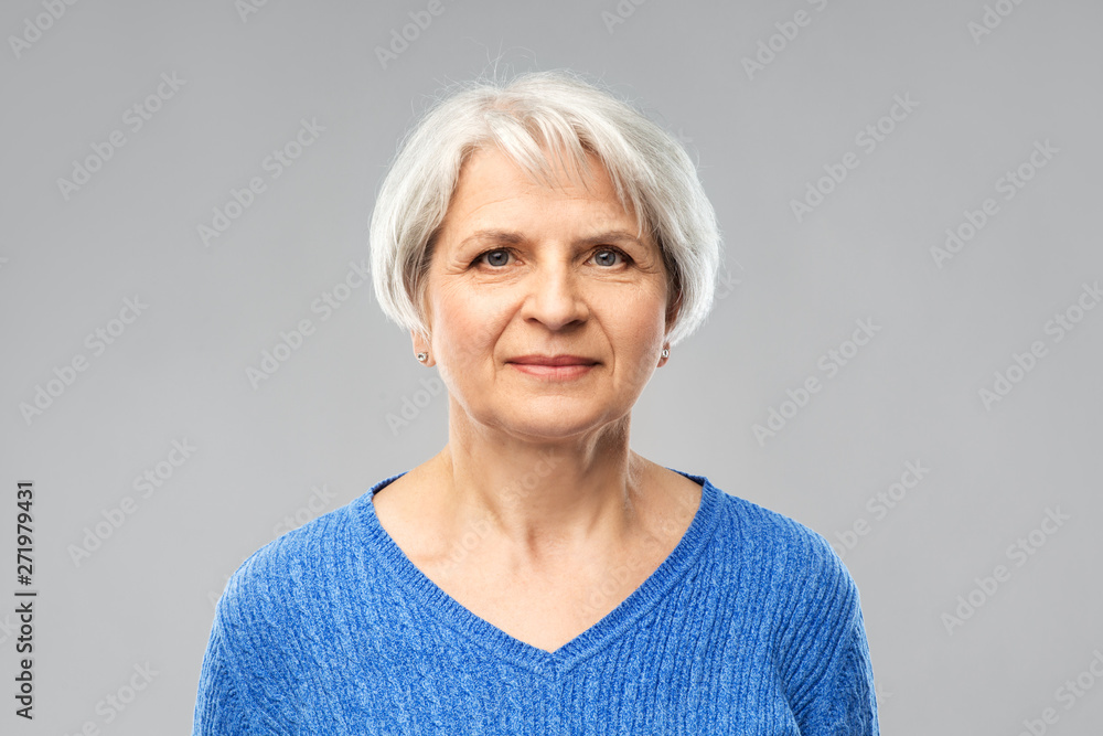 old people concept - portrait of senior woman in blue sweater over grey background old people concept - portrait of senior woman in blue sweater over grey background