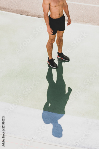 cropped view of shirtless sportsman standing at stadium