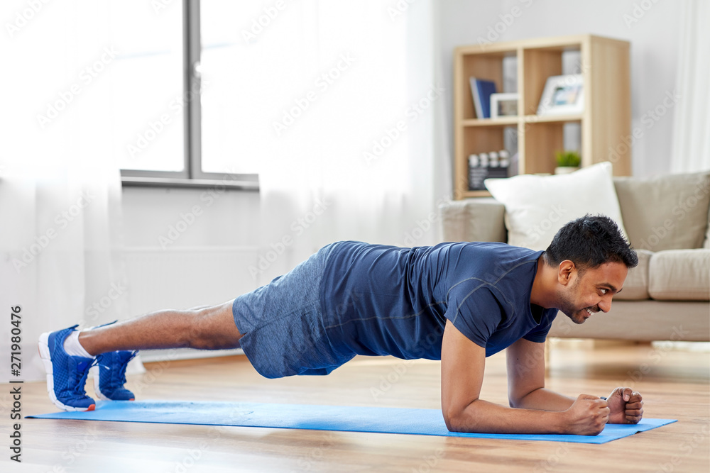 sport, fitness and healthy lifestyle concept - man doing plank exercise at home sport, fitness and healthy lifestyle concept - man doing plank exercise at home