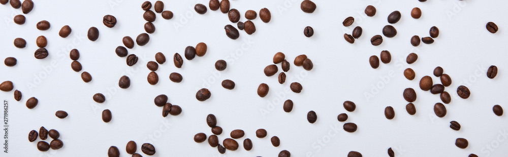 top view of coffee beans scattered on white background, panoramic shot top view of coffee beans scattered on white background, panoramic shot
