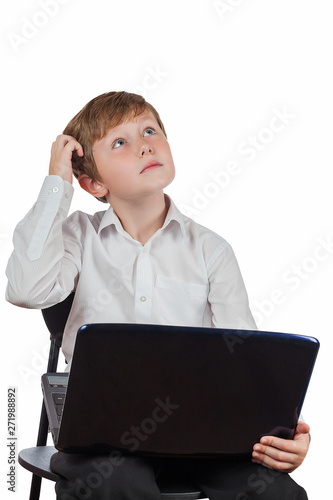 Scoolboy in the white shirt thought, holding a laptop on your lap, portrait isolated on white background photo