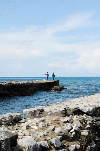 Fishermans with fishing rod on the pier in front of the sea. © Davide Zanin