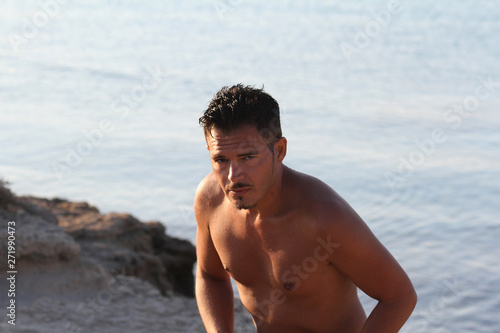 Handsome man with swimsuit are enjoying on the beach at sunset. Apulia  Salento  Italy