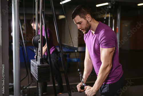 Fotografie Young adult bodybuilder healthy fitness man doing triceps overhead extension rope exercise