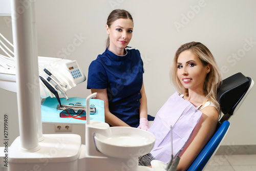 The woman came to see the dentist. Young woman having dental check-up in dentist's office, smiling, looking at camera. Happy patient and dentist concept.