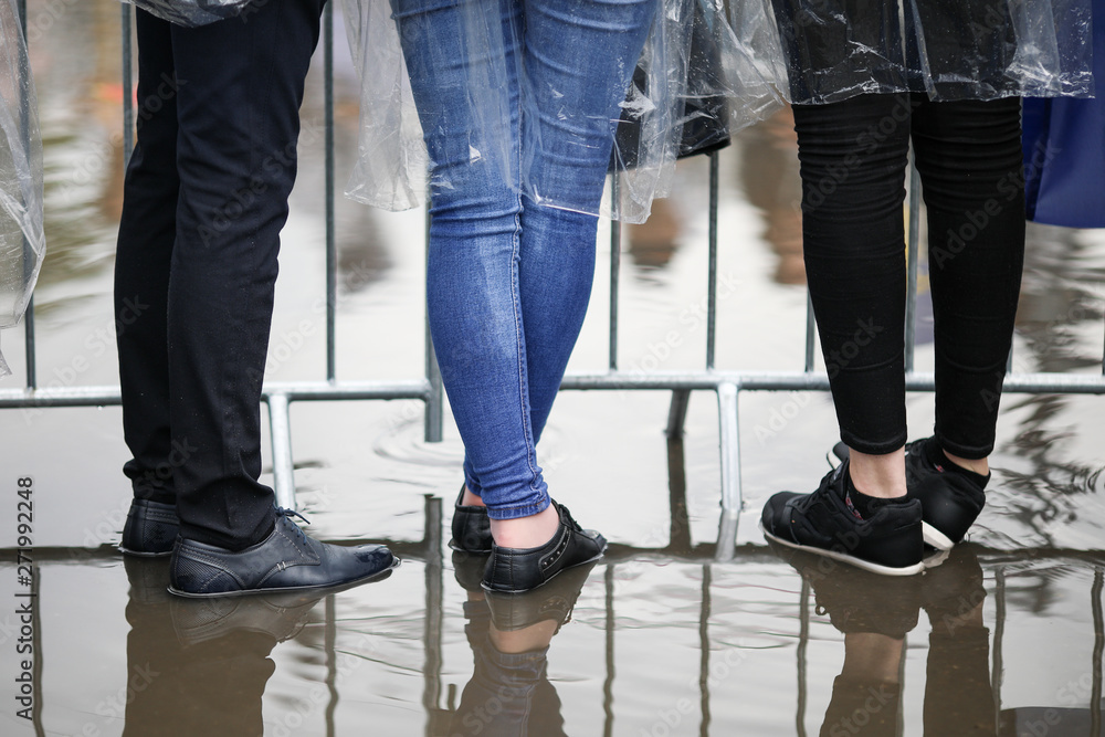 Details with the feet of young people standing in water at a public gathering (music festival) Details with the feet of young people standing in water at a public gathering (music festival)
