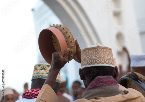 Sunni muslim men playing tambourines during the maulidi festivities in the street, Lamu county, Lamu town, Kenya photo