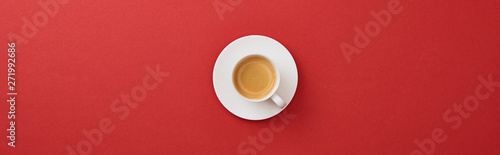 top view of white cup with fresh coffee on saucer on red background, panoramic shot
