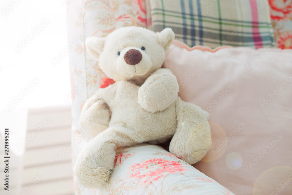 toy teddy bear sits in an armchair