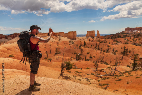Hiker taking a cellphone photo on trail in Bryce Canyon National Park, Utah, USA