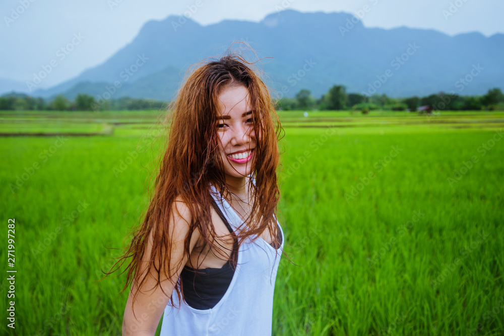 Asian women travel relax in the holiday.The girl smiled happy and enjoyed the rain that was falling. travelling in countrysde, Green rice fields, Travel Thailand. Asian women travel relax in the holiday.The girl smiled happy and enjoyed the rain that was falling. travelling in countrysde, Green rice fields, Travel Thailand.